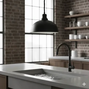 Industrial matte black pendant light hanging over an undermount kitchen sink with concrete countertops.
