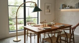 Brushed brass adjustable arc floor lamp hovering elegantly over a contemporary dining table