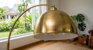 Close-up view of the polished brass dome shade on a gold arc floor lamp.