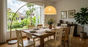 Oversized gold arc floor lamp centered over a farm-style dining room table.