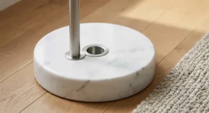 Close-up detail of a heavy white marble base on a stainless steel large arc floor lamp
