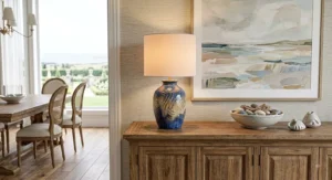 Large coastal style ceramic table lamp with a neutral shade on a dining room buffet