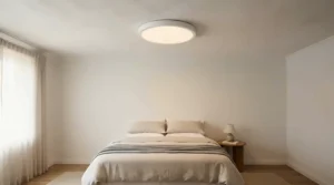 A sleek flush mount ceiling light for low-ceiling bedroom installed in a compact modern apartment sleeping area.