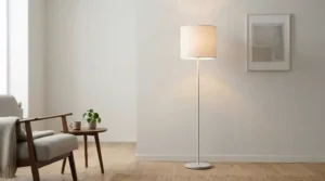 A minimalist white uplighter torchiere lamp illuminating a bright and airy small apartment interior.